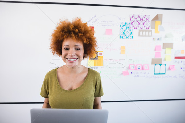 Portrait souriant femme d'affaires portable permanent [[stock_photo]] © wavebreak_media