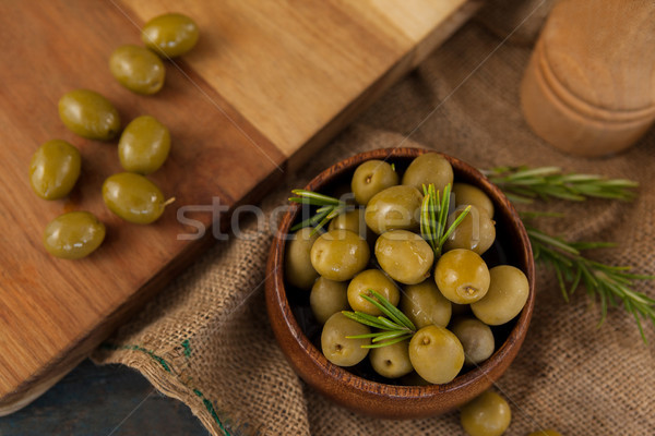 Olives with rosemary in bowl by cutting board Stock photo © wavebreak_media
