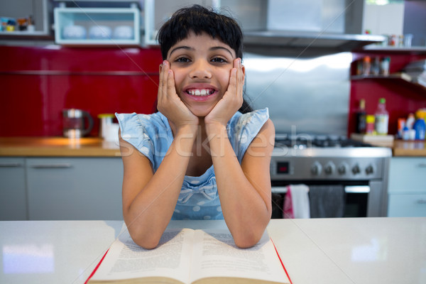Portret zâmbitor fată şedinţei bucătărie acasă Imagine de stoc © wavebreak_media