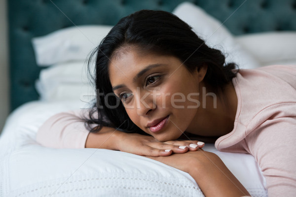 Thoughtful woman relaxing on bed Stock photo © wavebreak_media