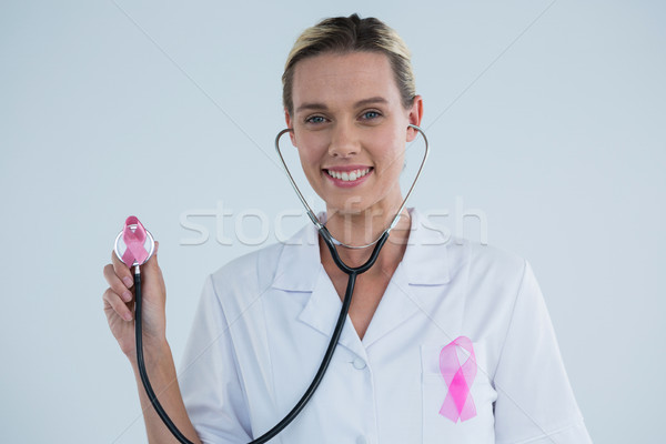 Doctor with stethoscope showing Breast Cancer Awareness ribbons Stock photo © wavebreak_media