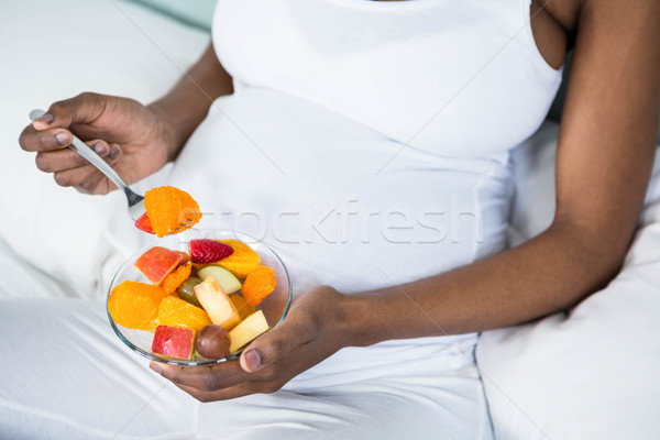 Mujer embarazada comer ensalada de fruta casa embarazadas cama Foto stock © wavebreak_media