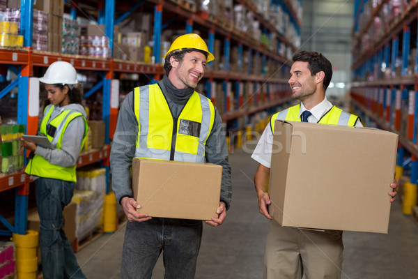 Workers holding box looking each other Stock photo © wavebreak_media