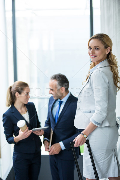 Foto stock: Retrato · empresária · mala · colegas · falante · prédio · comercial