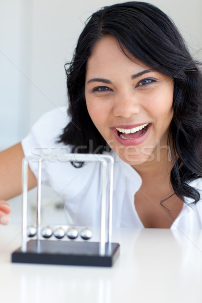 Stock photo: Smiling businesswoman playing with Newton balls