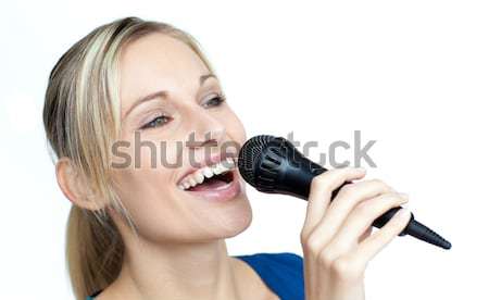 Stock photo: Delighted woman listening music with headphone and singing