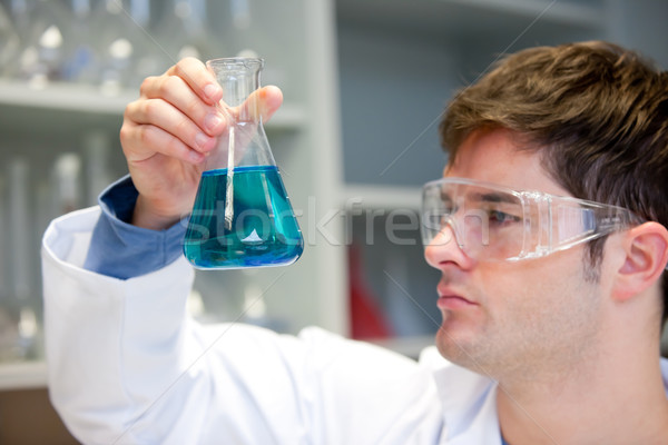 Jóvenes científico mirando líquido medicina azul Foto stock © wavebreak_media