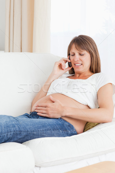 Portrait of a pregnant woman phoning in her living room Stock photo © wavebreak_media