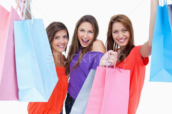 Stock photo: Happy teenagers raising their arms while holding their purchase bags