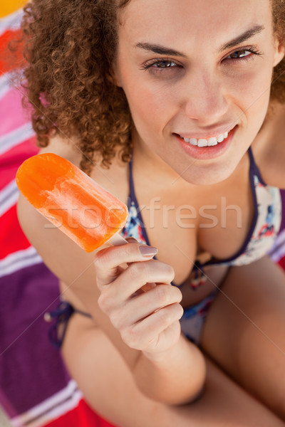 Young attractive woman in bikini holding an ice lolly while looking at the camera Stock photo © wavebreak_media