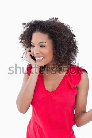 Smiling woman looking at the camera while calling against a white background Stock photo © wavebreak_media