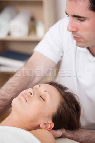 Serious doctor manipulating his patient in a room Stock photo © wavebreak_media