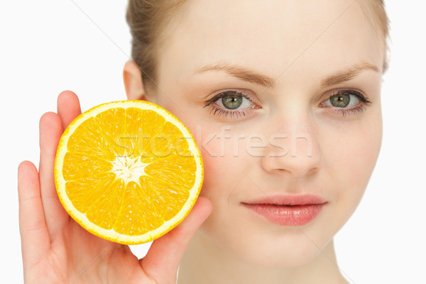 Close up of a woman presenting an orange against white background Stock photo © wavebreak_media