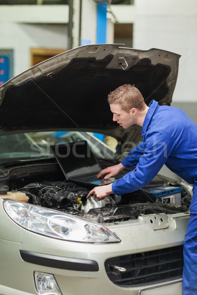 Auto mechanic with laptop repairing car Stock photo © wavebreak_media