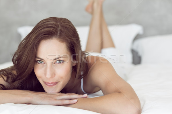 Closeup of a pretty smiling woman lying in bed Stock photo © wavebreak_media