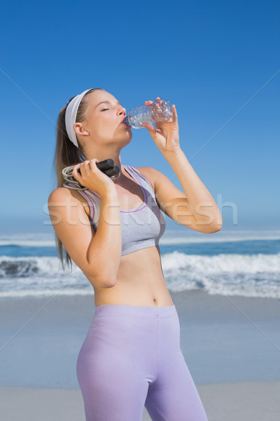 Sporty blonde standing on the beach drinking water  Stock photo © wavebreak_media