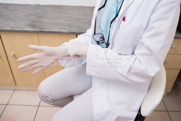 Dentist pulling on surgical gloves Stock photo © wavebreak_media