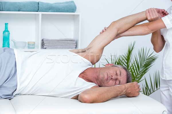 Doctor stretching her patient arm Stock photo © wavebreak_media