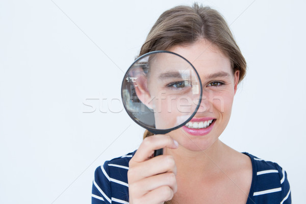 Stock photo: Smiling woman holding magnifying glass