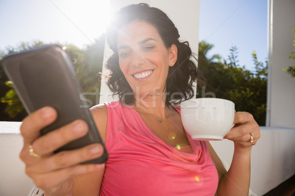 Foto stock: Sorridente · mulher · jovem · telefone · móvel · xícara · de · café · café