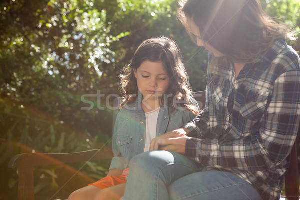 Beautiful mother sitting with girl on bench against plants at backyard Stock photo © wavebreak_media