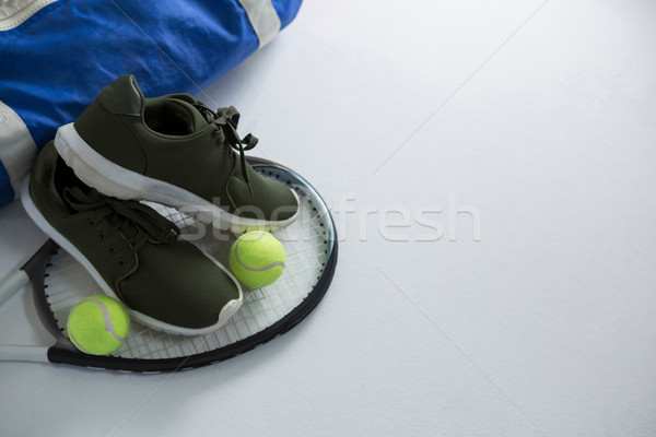 Sports shoe and tennis balls on racket by bag Stock photo © wavebreak_media