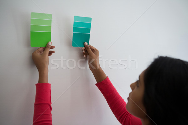 Young woman holding color swatches by wall Stock photo © wavebreak_media