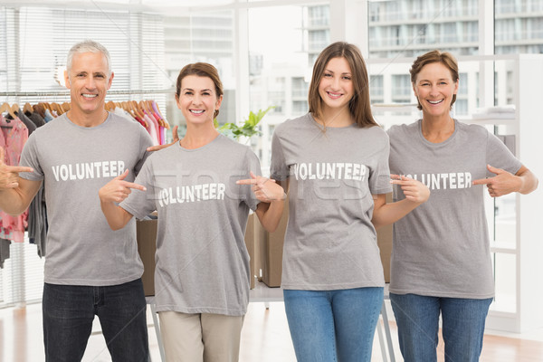 Smiling volunteers pointing on their shirts Stock photo © wavebreak_media