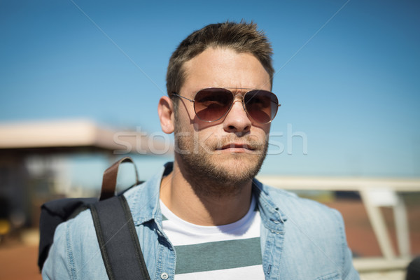 Foto stock: Homem · óculos · de · sol · em · pé · mochila · beber