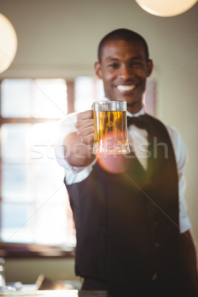Sorridere barista offrendo vetro birra bar Foto d'archivio © wavebreak_media