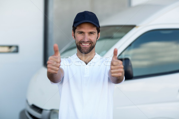 Portrait of delivery man is posing and smiling with thumbs up Stock photo © wavebreak_media