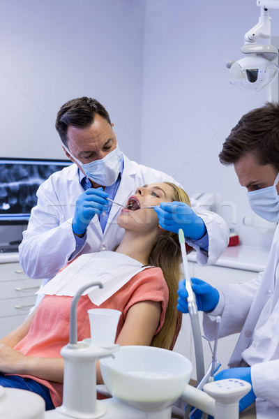 Dentists examining a male patient with tools Stock photo © wavebreak_media