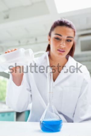 Pretty red-haired woman holding a test tube in a lab Stock photo © wavebreak_media