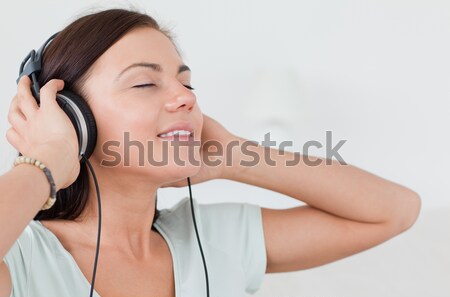 Close up of a lovely woman listening to music with her eyes closed Stock photo © wavebreak_media