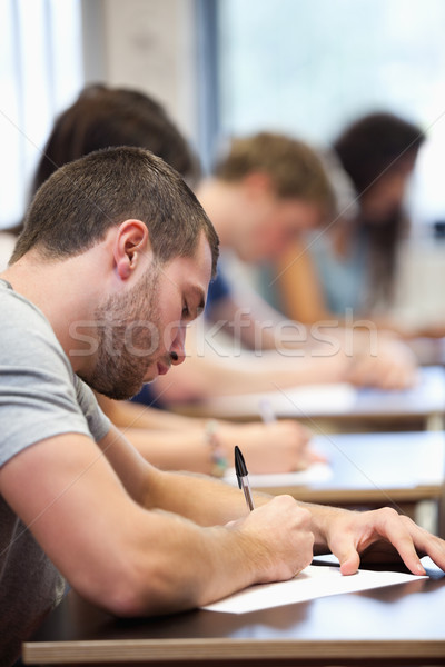 Portrait of a young man writing in a classroom Stock photo © wavebreak_media