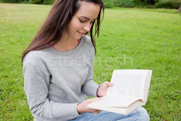 Young relaxed girl attentively reading a book while sitting down in a parkland Stock photo © wavebreak_media