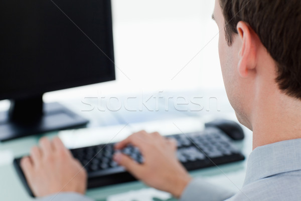 Back view of a businessman working with a monitor in his office Stock photo © wavebreak_media