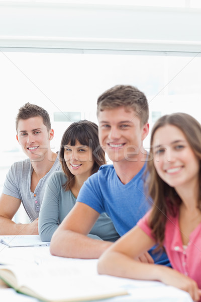 Stock photo: A close up side view shot of smiling students looking and turned to the camera 