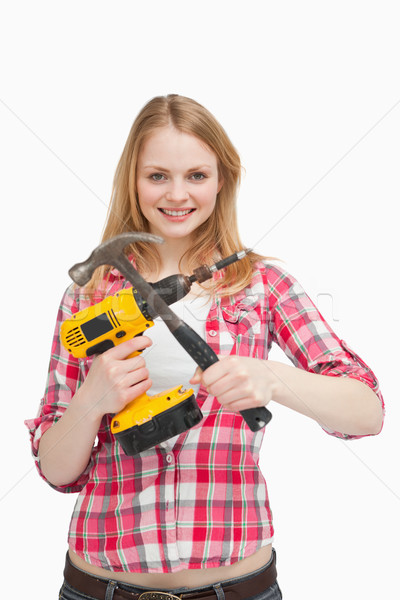 Young woman holding tools against white background Stock photo © wavebreak_media