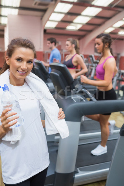 Woman smiling and drinking a bottle of water in the gym after exercise Stock photo © wavebreak_media