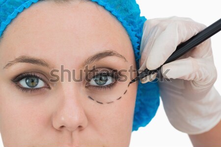 Plastic surgeon writing on woman's face on the white background Stock photo © wavebreak_media