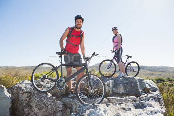 Fit cyclist couple standing at the summit smiling at camera Stock photo © wavebreak_media