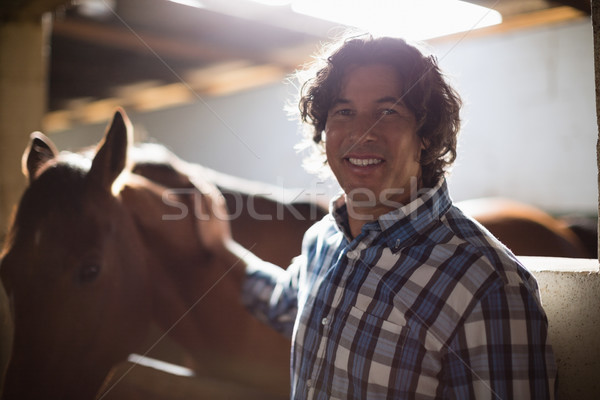 Man caressing the brown horse in the stable Stock photo © wavebreak_media