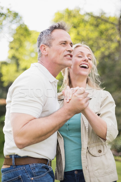 Cute couple danse mains tenant à l'extérieur femme [[stock_photo]] © wavebreak_media