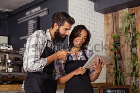 Smiling couple using mobile phone while having glass of beer in bar Stock photo © wavebreak_media