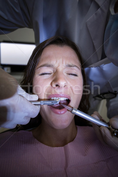Dentist examining a female patient with tools Stock photo © wavebreak_media