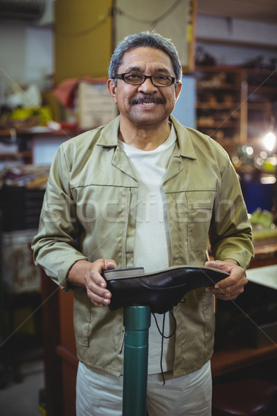 Portrait of smiling shoemaker examining a shoe Stock photo © wavebreak_media