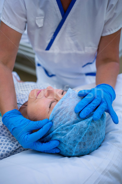 Nurse putting a surgical cap to patient Stock photo © wavebreak_media