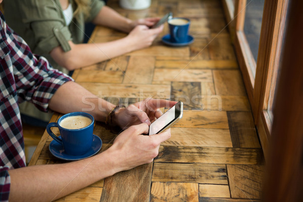Férfi nő mobiltelefonok kávéház telefon képernyő Stock fotó © wavebreak_media