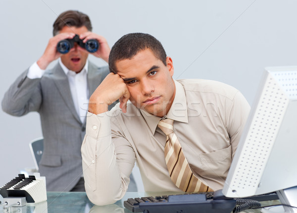 Handsome businessman getting bored and his manager looking through binoculars Stock photo © wavebreak_media
